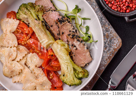 Bowl with slices of baked tuna with broccoli, tomatoes and fusili pasta 118661129