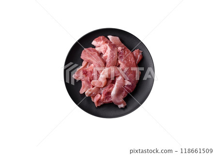 A pieces of raw fresh pork on a wooden cutting board with spices and herbs A pieces of raw fresh pork on a wooden cutting board with spices and herbs 118661509