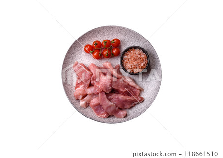 A pieces of raw fresh pork on a wooden cutting board with spices and herbs A pieces of raw fresh pork on a wooden cutting board with spices and herbs 118661510
