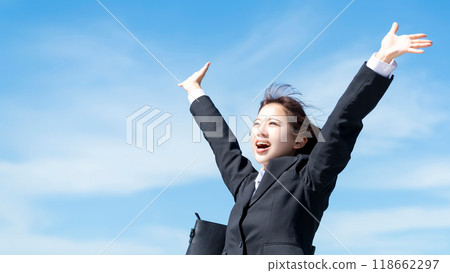 A young woman, job seeker or new employee, spreading her arms out in the blue sky 118662297