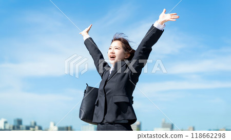 A young woman, job seeker or new employee, spreading her arms out in the blue sky 118662298