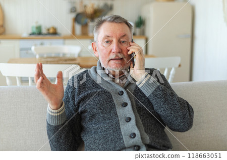Happy middle aged senior man talking on smartphone with family friends. Older mature grandfather with cell phone talking with grown up children, resting at home. Older generation modern tech usage Happy middle aged senior man talking on smartphone with family friends. Older mature grandfather with cell phone talking with grown up children, resting at home. Older generation modern tech usage 118663051