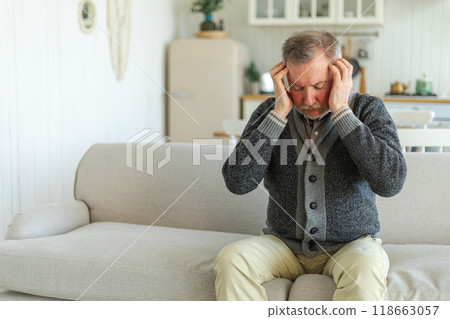 Headache pain. Unhappy middle aged senior man suffering from headache sick rubbing temples at home. Mature old senior grandfather touching temples experiencing stress. Man feeling pain hurt in head 118663057