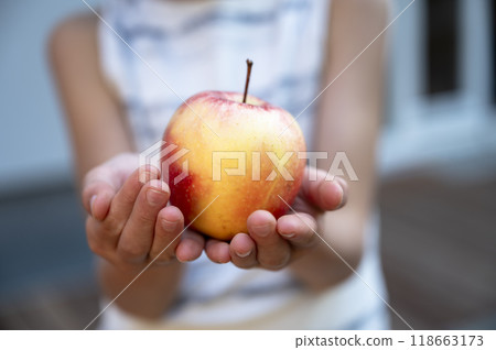 Hand of a child holding an apple Hand of a child holding an apple 118663173