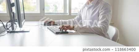 Student or programmer sitting at his desk working 118663400