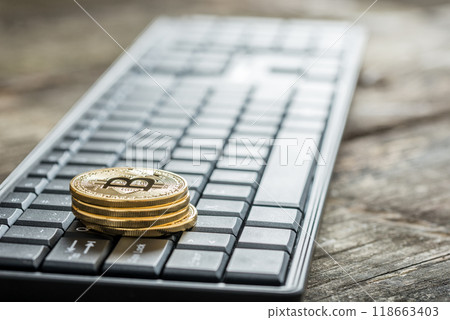 Close-up of four bitcoins on a wireless keyboard Close-up of four bitcoins on a wireless keyboard 118663403