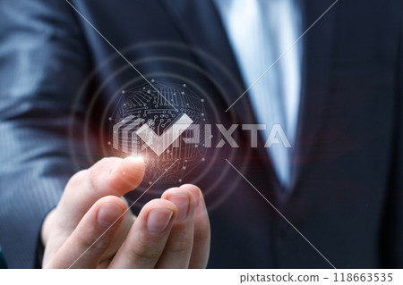 A businessman shows a check mark in his hand . 118663535