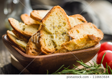 Crispy roasted bruschetta bread in bowl on wooden table. Crispy roasted bruschetta bread in bowl on wooden table. 118663684