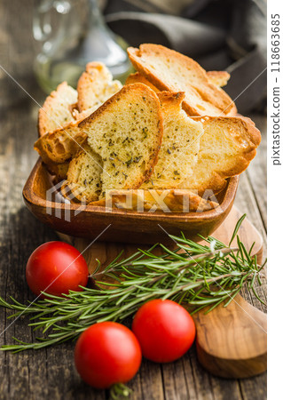Crispy roasted bruschetta bread in bowl on wooden table. Crispy roasted bruschetta bread in bowl on wooden table. 118663685