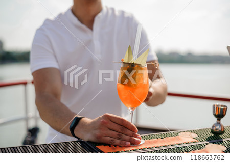 Refreshing Tropical Cocktail Served on a Floating Bar with Scenic Water View Refreshing Tropical Cocktail Served on a Floating Bar with Scenic Water View 118663762