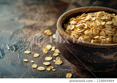 Raw oatmeal in a bowl on a dark background. Selective focus. 118664464