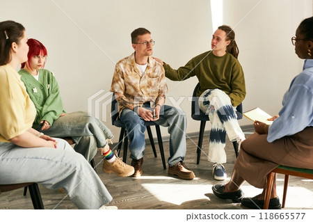 Diverse group of individuals engaging in group therapy session, listening and participating in an informal setting with bright flooring and relaxed atmosphere Diverse group of individuals engaging in group therapy session, listening and participating in an informal setting with bright flooring and relaxed atmosphere 118665577