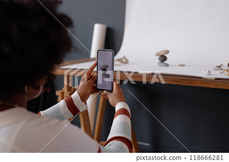 Back view of African American woman doing professional photoshoot with smartphone mobile photography in studio copy space Back view of African American woman doing professional photoshoot with smartphone mobile photography in studio copy space 118666281