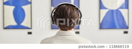Header image with minimal back view of unrecognizable man wearing headphones looking at abstract paintings copy space Header image with minimal back view of unrecognizable man wearing headphones looking at abstract paintings copy space 118666519