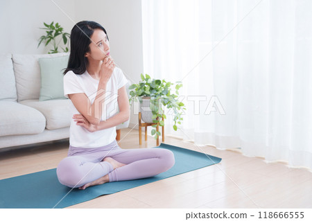 A thinking woman wearing yoga wear A thinking woman wearing yoga wear 118666555