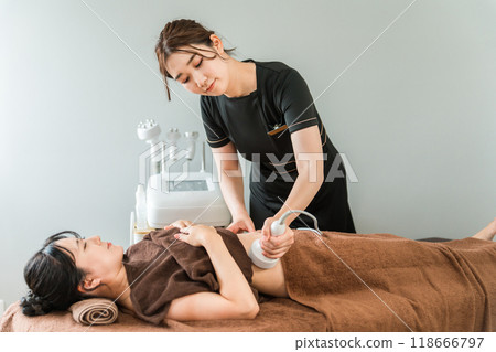 美容師和女性在美容院使用空化美容機進行減肥美容治療 118666797