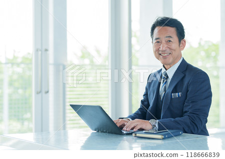 Middle-aged businessman using a computer Middle-aged businessman using a computer 118666839