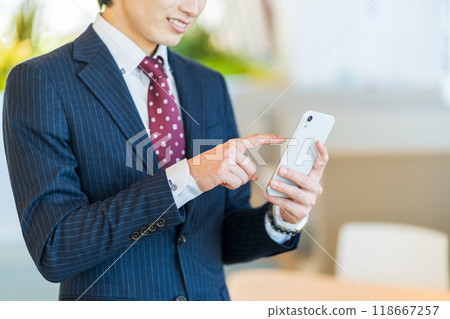 A businessman operating a smartphone (parts) Photo courtesy of Denpa Gakuen, Tokyo Electronics College 118667257