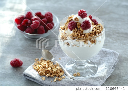 Yogurt decorated with raspberries and crunchy granola for a healthy breakfast 118667441