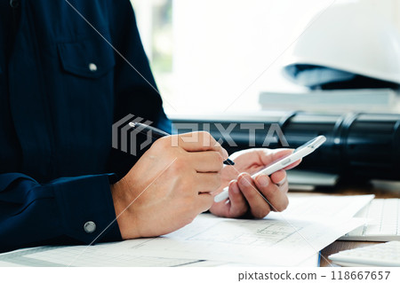 Man in work clothes operating a smartphone 118667657
