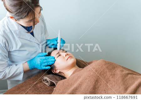 A woman getting her eyebrows done at a permanent makeup marking/design/eyebrow salon/eyebrow beauty salon 118667691