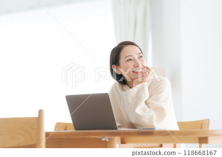 A woman who operates a personal computer at home 118668167