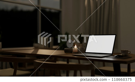 A close-up of a laptop mockup on a dining table in a contemporary dining room at night. 118668375