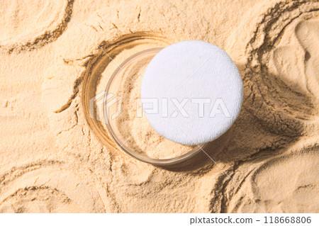 A bottle of light-colored powder on a yellow background. 118668806