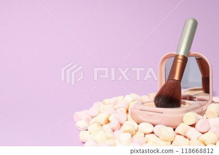 A bottle of loose powder, light shade, on a purple background. 118668812