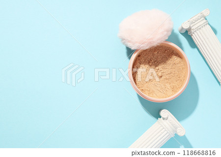 A bottle of loose powder, light shade, on a blue background. 118668816
