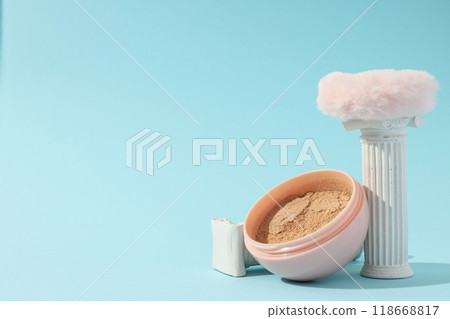 A bottle of loose powder, light shade, on a blue background. 118668817
