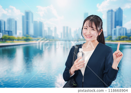 一位年輕女子拿著塑膠瓶微笑著上班 一位年輕女子拿著塑膠瓶微笑著上班 118668904