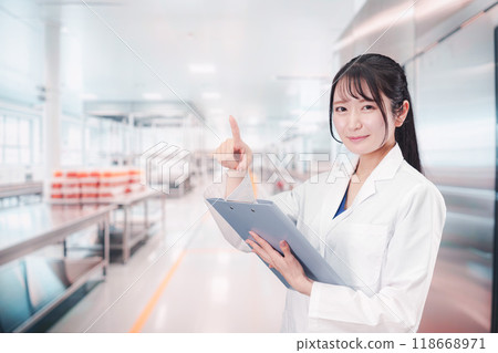 A young woman working at a food manufacturer 118668971