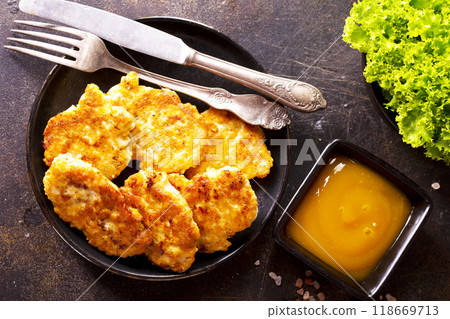 white fish cutlets on black plate white fish cutlets on black plate 118669713