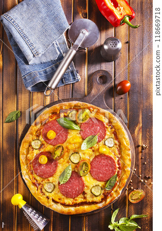 Tasty pepperoni pizza with basil on wooden table Tasty pepperoni pizza with basil on wooden table 118669718