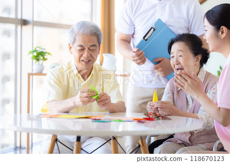 Care image: Seniors and caregivers folding origami 118670123