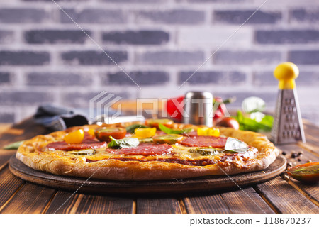 Tasty pepperoni pizza with basil on wooden table Tasty pepperoni pizza with basil on wooden table 118670237
