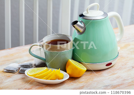 Electric kettle and cup of tea on table Electric kettle and cup of tea on table 118670396