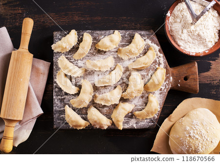 Raw dumplings varenik - traditional Ukrainian food - on wooden board close up. Raw dumplings varenik - traditional Ukrainian food - on wooden board close up. 118670566
