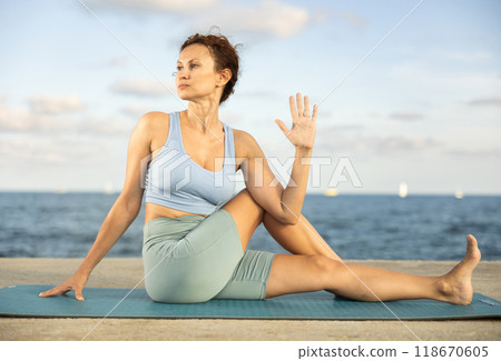 Woman performing Ardha Matsyendrasana position yoga training 118670605