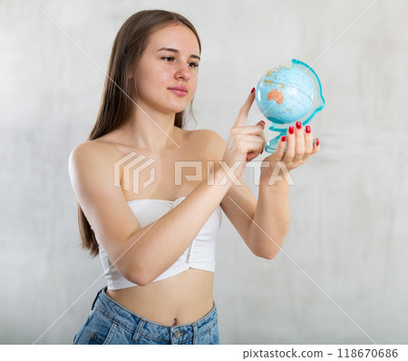 Young woman with globe posing in studio 118670686