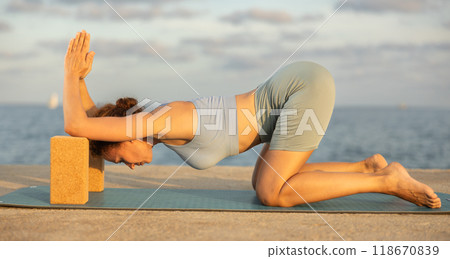Female yoga instructor performing various asana poses using rectangular blocks Female yoga instructor performing various asana poses using rectangular blocks 118670839