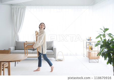 一個女人在客廳搬椅子 118670916