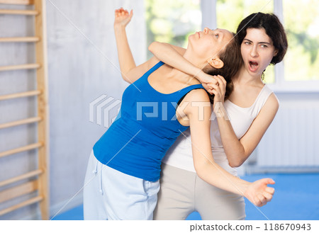 Woman makes a choke hold in self defense trainin Woman makes a choke hold in self defense trainin 118670943