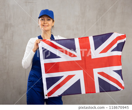Smiling adult woman in uniform holding UK flag 118670945