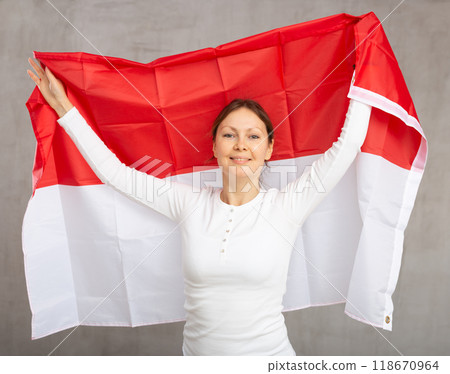 Happy woman posing with national flag of Monaco in studio 118670964