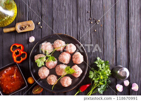 Fresh raw beef meatballs with spices and tomato sauce 118670991