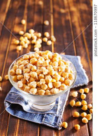 Glass bowl filled with boiled chickpeas on a rustic table. 118670997