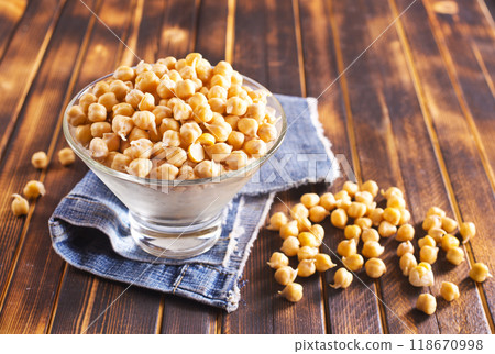 Glass bowl filled with boiled chickpeas on a rustic table. 118670998