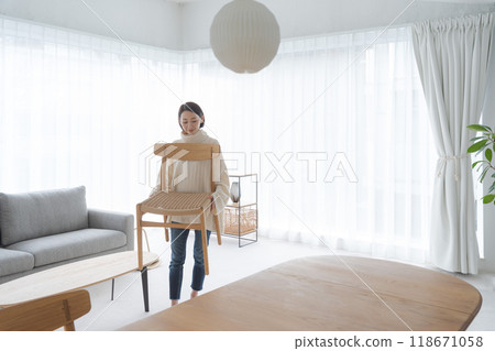 一個女人在客廳搬椅子 一個女人在客廳搬椅子 118671058